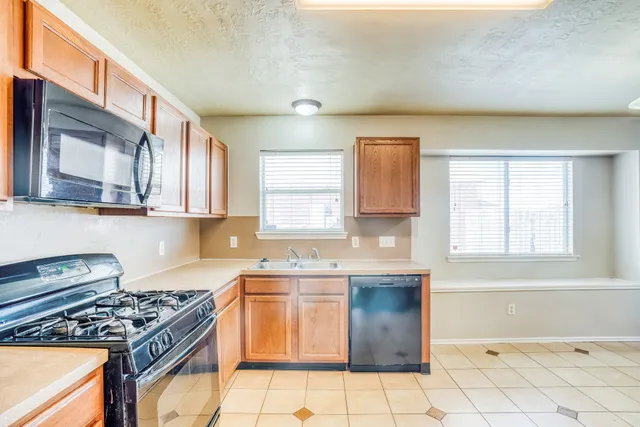 a kitchen with stainless steel appliances a stove a sink and a microwave