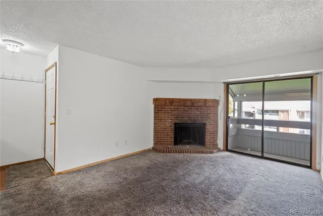 a view of an empty room with a fireplace and a window