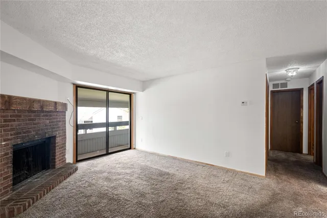 an empty room with windows and fireplace