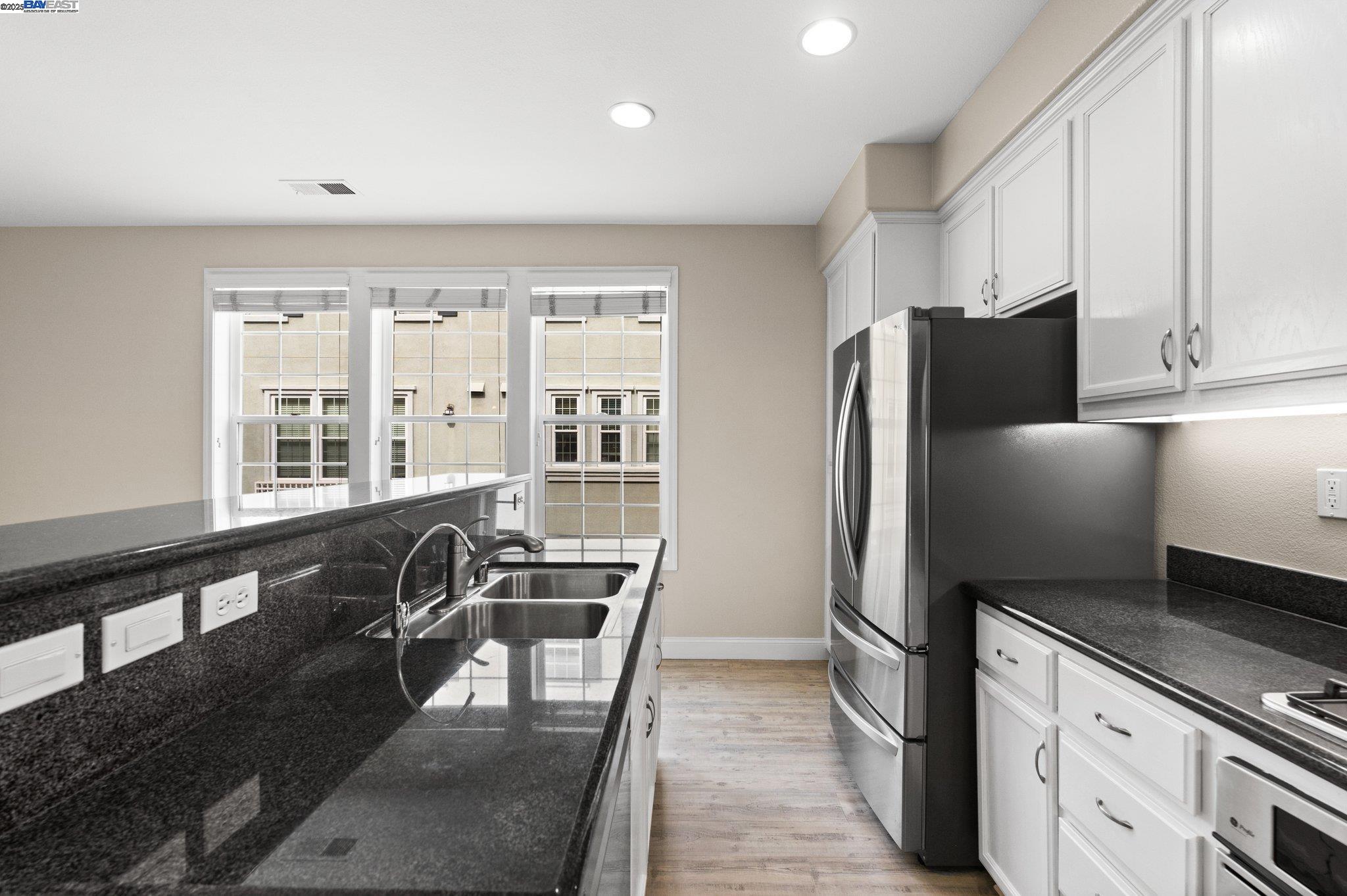 3658 Whitworth Drive Dublin, CA 94568 - Photo 13 of 36 a kitchen with stainless steel appliances granite countertop a refrigerator a stove a sink a dining table and chairs with wooden floor