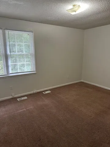 an empty room with a chandeliers fan