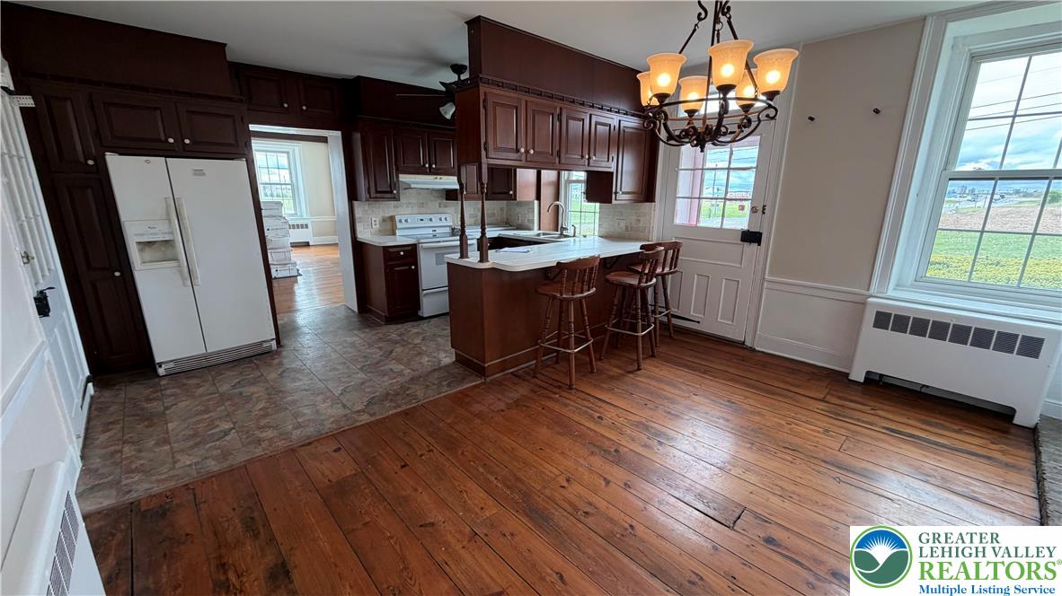797 Main Street Tatamy, PA 18085 - Photo 37 of 41 a kitchen with stainless steel appliances granite countertop a refrigerator a sink dishwasher a stove and a dining table with wooden floor