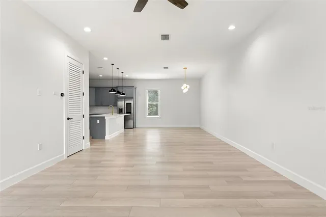 a large kitchen with kitchen island a sink stainless steel appliances and a chandelier