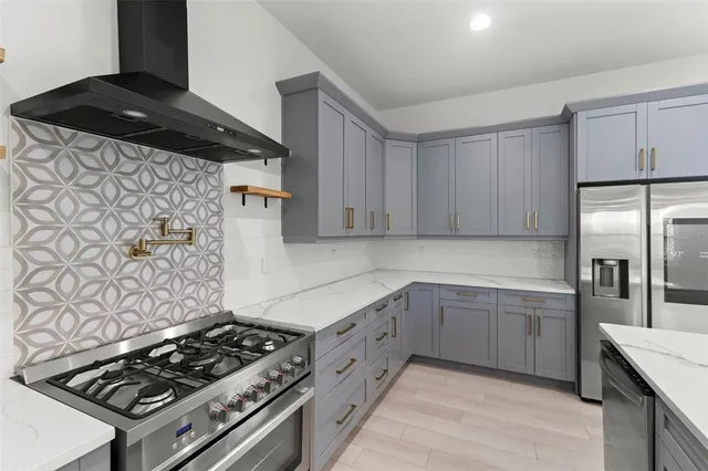 a large kitchen with kitchen island a sink stainless steel appliances and a chandelier