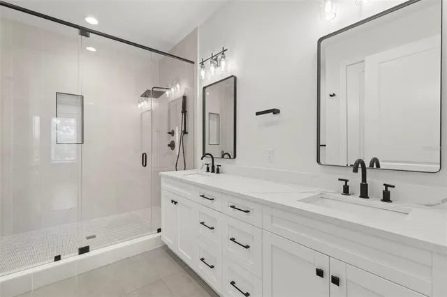 a bathroom with a double vanity sink mirror and shower
