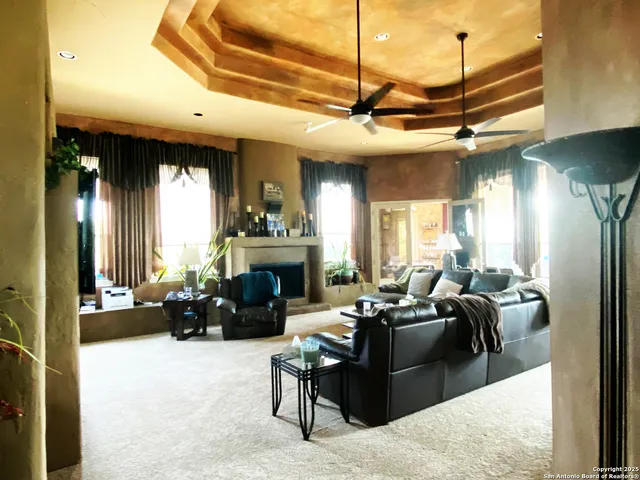 a living room with furniture a fireplace and a chandelier