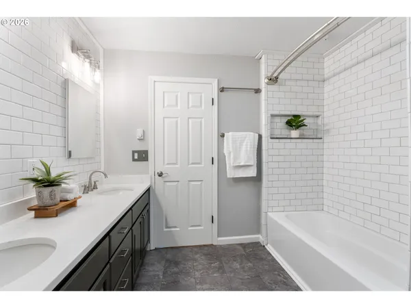 a bathroom with a bathtub sink and mirror