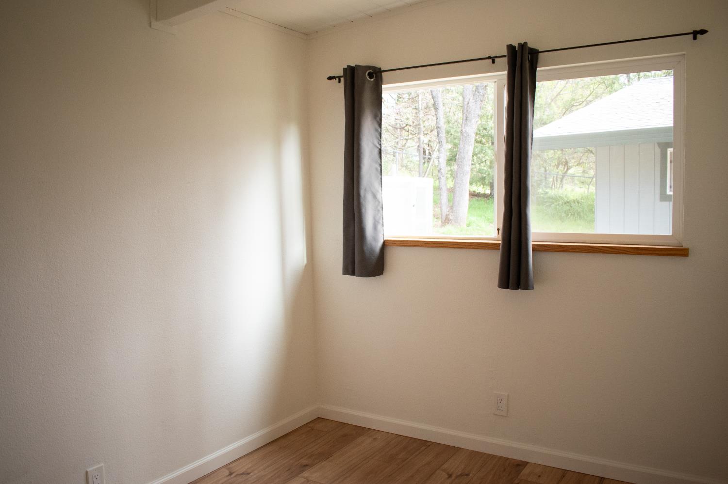 4881 Marshall Road Garden Valley, CA 95633 - Photo 17 of 25 a view of an empty room with wooden floor and windows