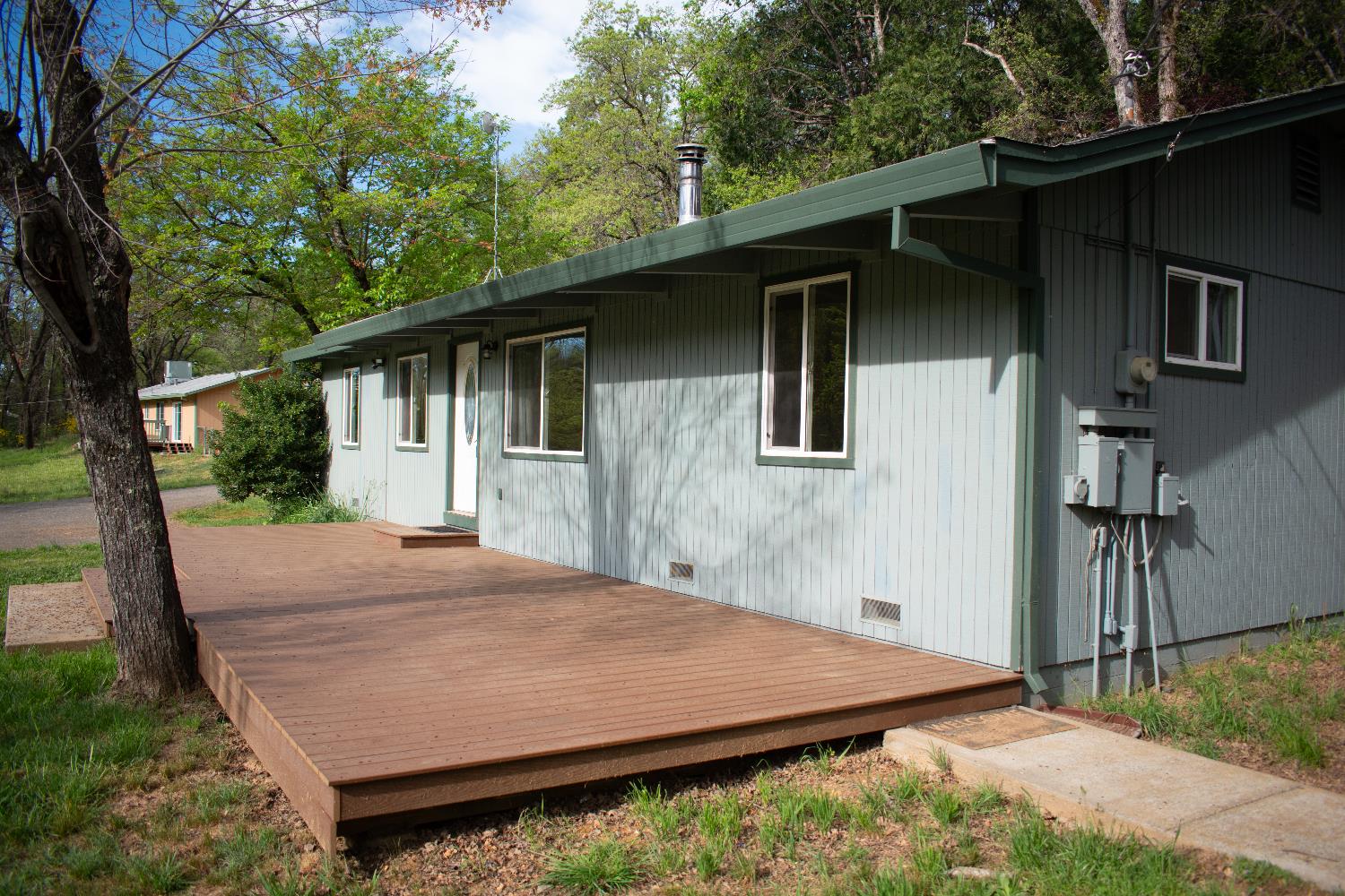 4881 Marshall Road Garden Valley, CA 95633 - Photo 2 of 25 a backyard of a house with large trees and brick wall