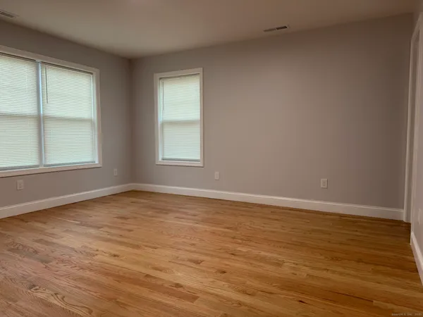 an empty room with wooden floor & closet area