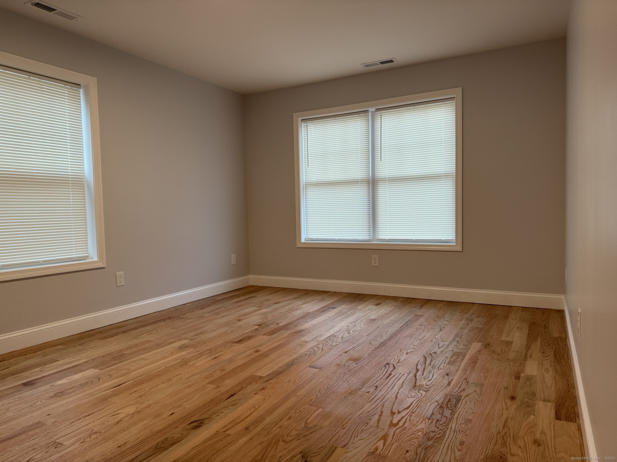 755 Hart Street Bridgeport, CT 06606 - Photo 17 of 37 an empty room with wooden floor and windows