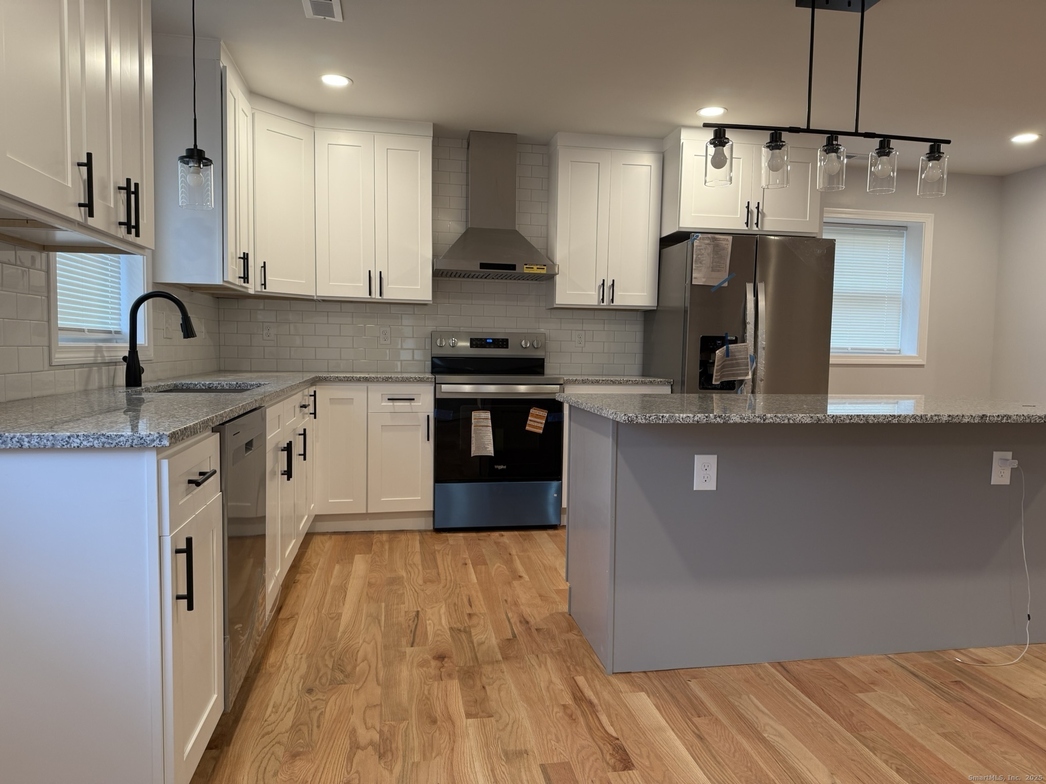 755 Hart Street Bridgeport, CT 06606 - Photo 30 of 37 a kitchen with stainless steel appliances granite countertop a sink a stove top oven a refrigerator with island and chairs