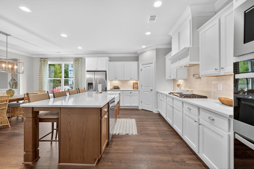 5649 Ernest Way Flowery Branch, GA 30542 - Photo 10 of 69 a kitchen with stainless steel appliances granite countertop a table chairs sink and cabinets
