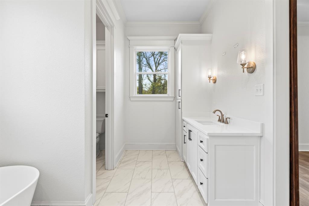 12171 Copper Court Tyler, TX 75706 - Photo 23 of 40 a spacious bathroom with a double vanity sink a toilet and a window