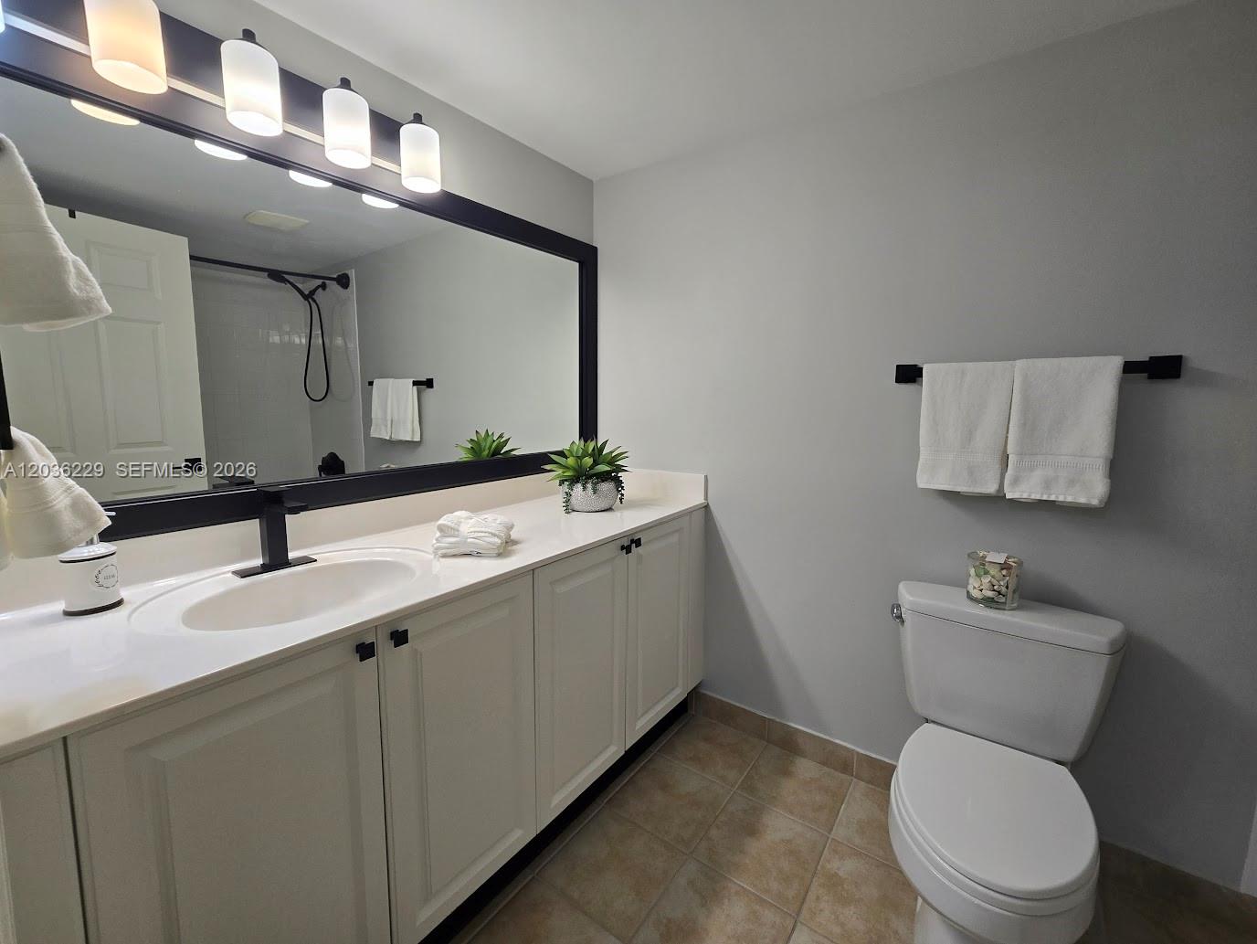 888 Douglas Road, Unit 605 Coral Gables, FL 33134 - Photo 14 of 21 a bathroom with a toilet sink and mirror