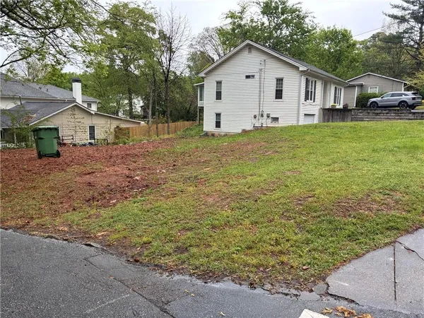 a view of a yard in front of a house with large tree