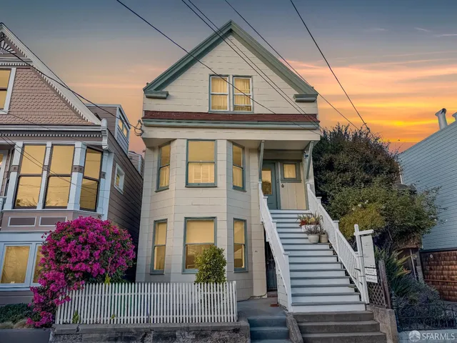 a view of a brick house with wooden fence and windows