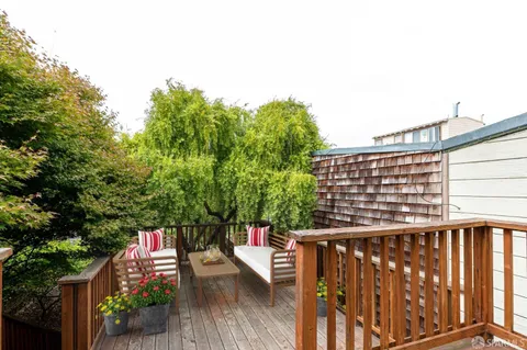 a view of balcony with wooden floor and seating space