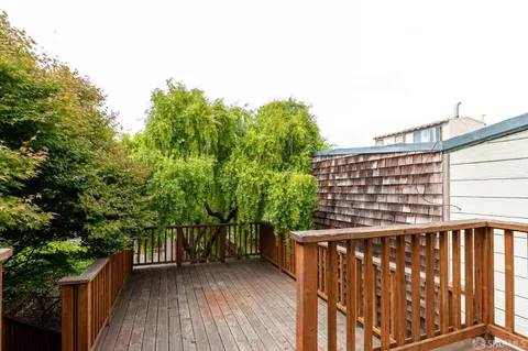 a view of balcony with wooden floor and fence