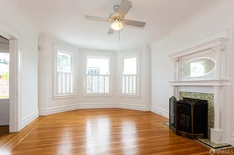 a view of empty room with fireplace and wooden floor