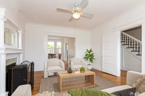 a living room with furniture a chandelier and a rug