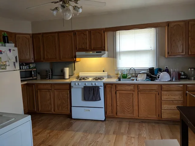 a kitchen with granite countertop wooden cabinets a sink and dishwasher