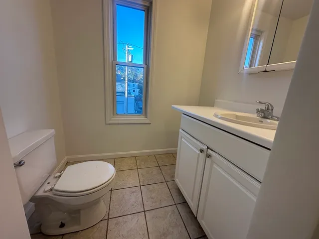 a bathroom with a sink toilet and window