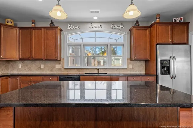 a kitchen with stainless steel appliances granite countertop a stove and a wooden floors