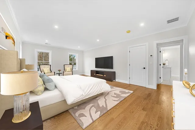 a large bedroom with a bed and a flat screen tv