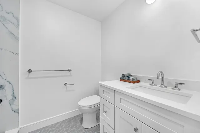 a bathroom with a sink a toilet and a mirror