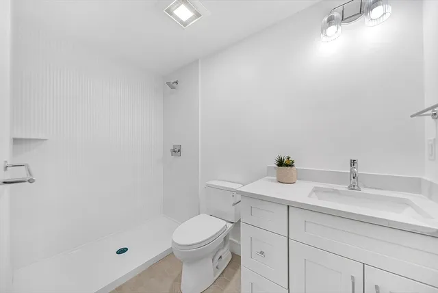 a bathroom with a sink a toilet and shower