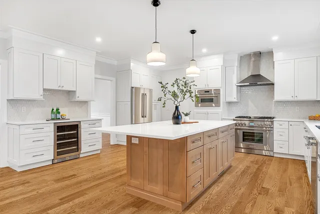 a kitchen with kitchen island a stove a sink a center island and wooden floor