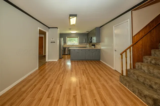 a view of a kitchen with wooden floor and electronic appliances