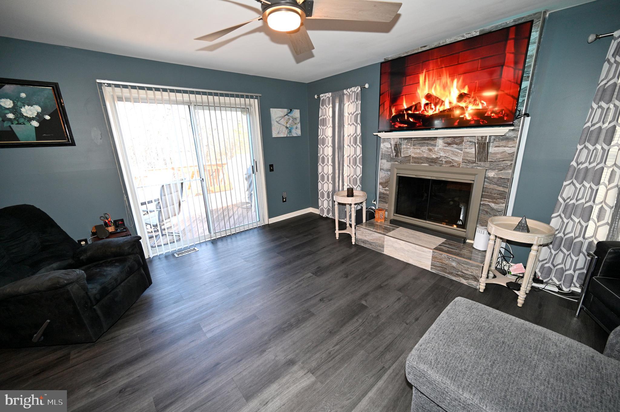 7729 Castle Rock Drive Clinton, MD 20735 - Photo 13 of 65 a living room with furniture a flat screen tv and a fireplace