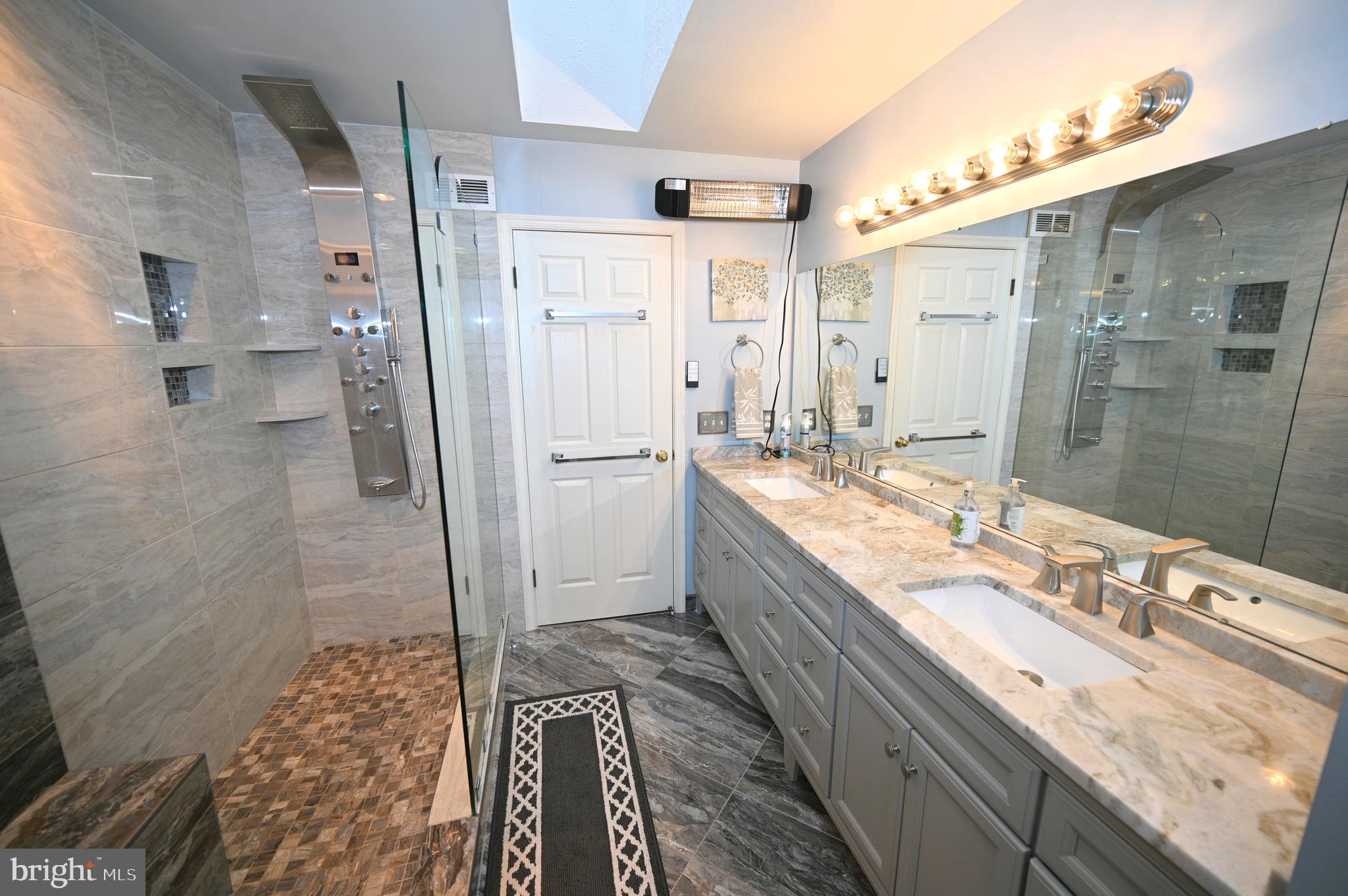 7729 Castle Rock Drive Clinton, MD 20735 - Photo 33 of 65 a bathroom with a granite countertop double vanity sink a mirror and a shower