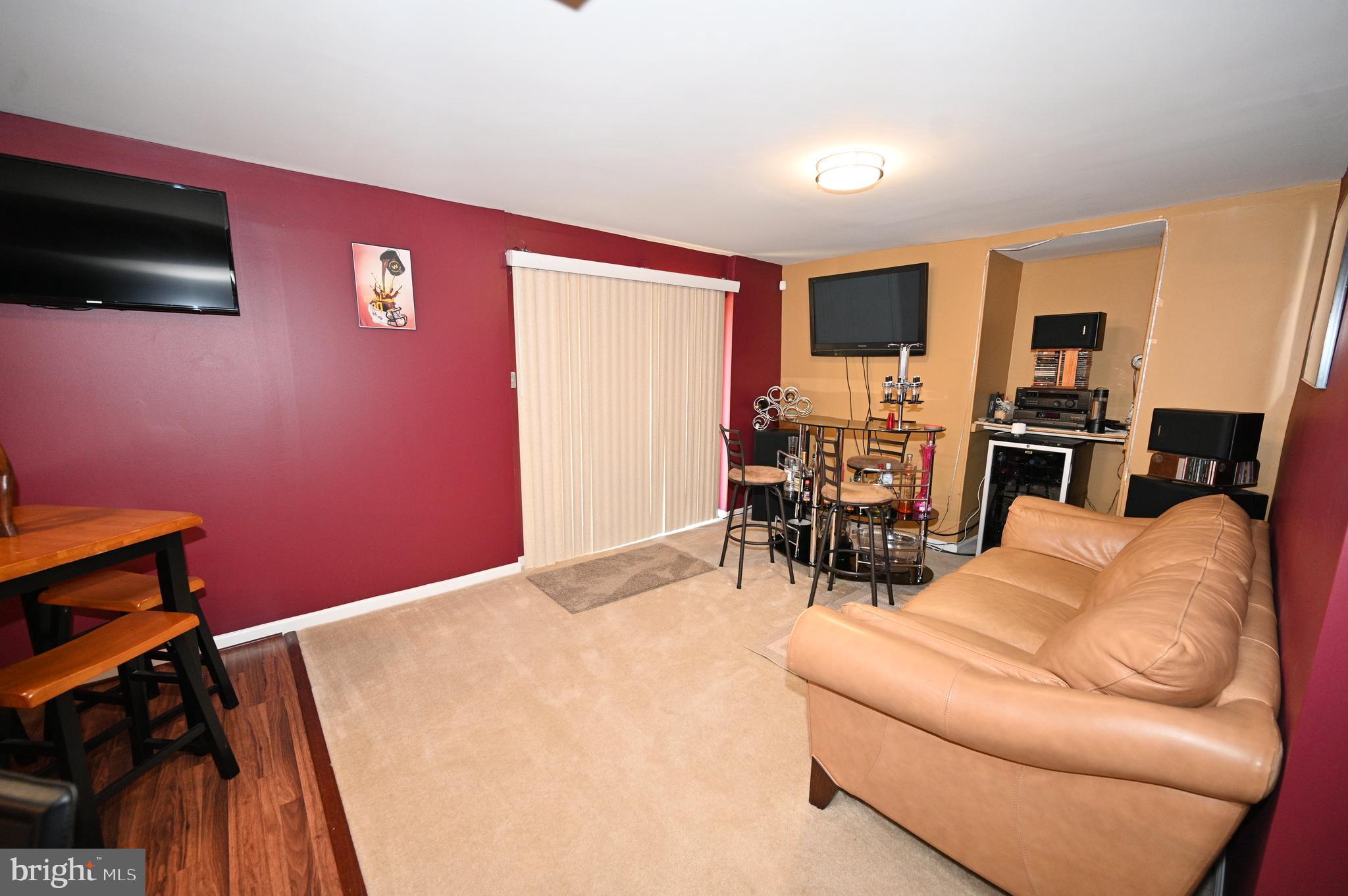 7729 Castle Rock Drive Clinton, MD 20735 - Photo 52 of 65 a living room with furniture a flat screen tv and kitchen view