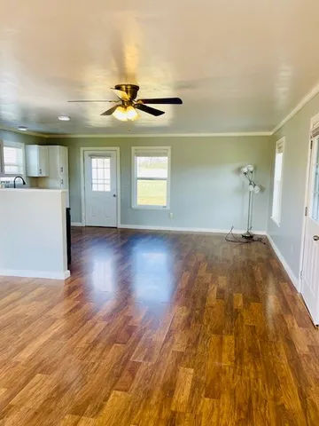 a view of a room with wooden floor and windows
