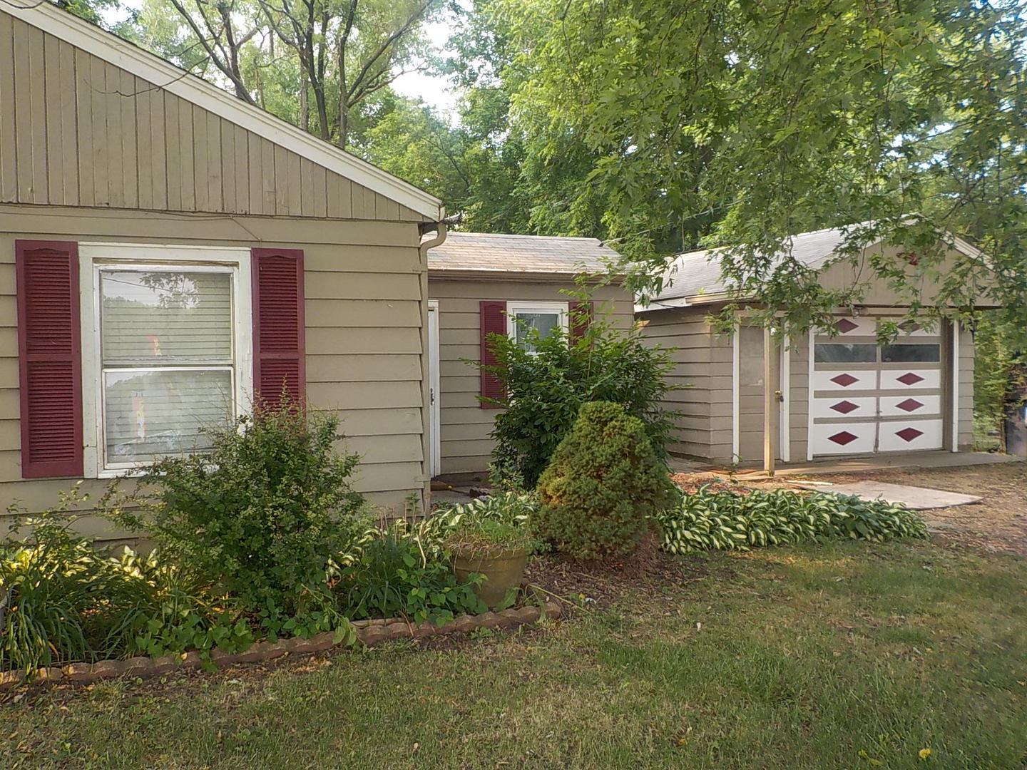 2125 Windsor Road Loves Park, IL 61111 - Photo 1 of 12 a front view of a house with a garden
