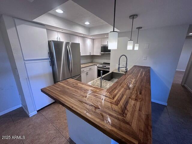 a kitchen with stainless steel appliances granite countertop a refrigerator a sink a stove and a wooden floors