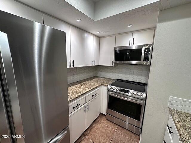 2935 North 68th Street, Unit 127 Scottsdale, AZ 85251 - Photo 11 of 25 a kitchen with stainless steel appliances granite countertop a refrigerator a stove a sink and a microwave