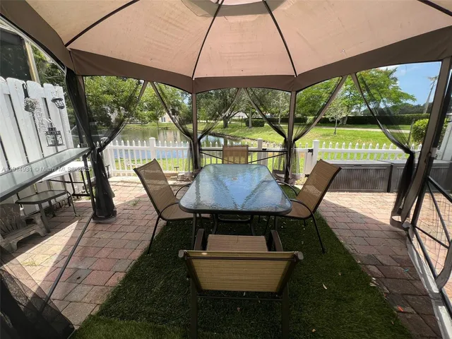 a view of a house with wooden deck and furniture