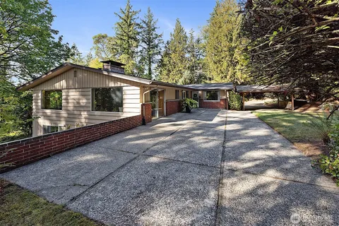a front view of a house with yard and trees