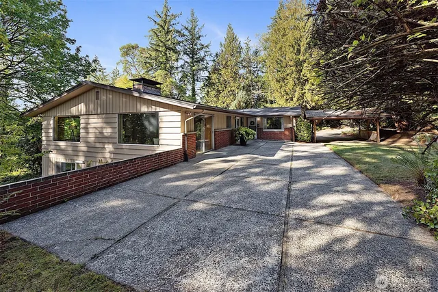 a front view of a house with yard and trees