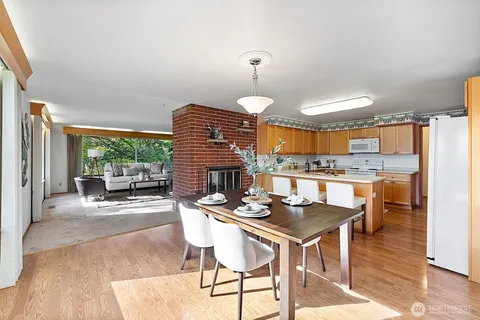 a dining room with stainless steel appliances a table and chairs with kitchen view