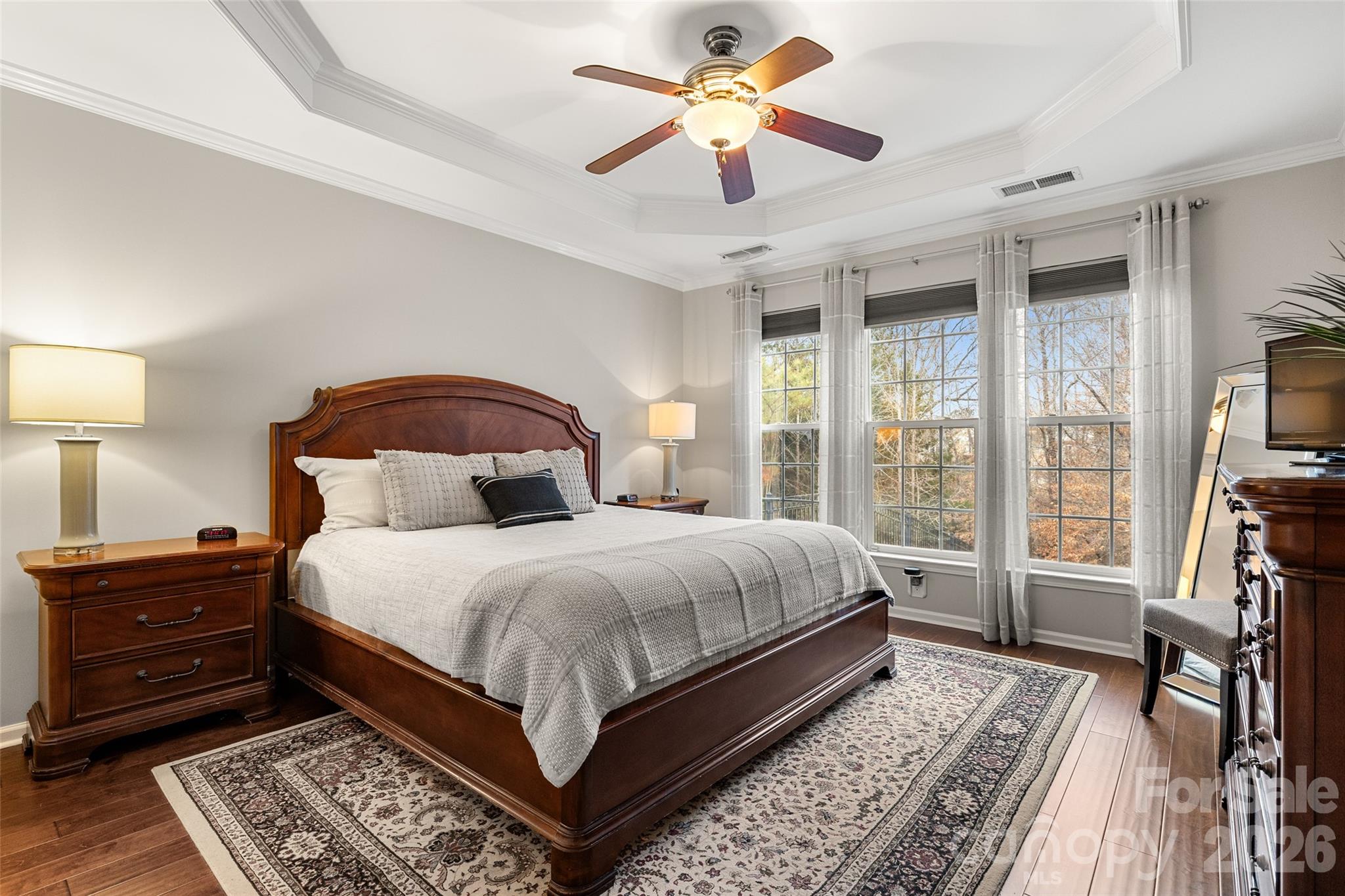 10564 Bethpage Drive Fort Mill, SC 29707 - Photo 17 of 47 a bedroom with a large bed a flat tv screen and a bookshelf