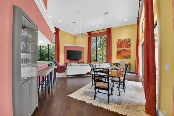 a living room with furniture a flat screen tv and a floor to ceiling window