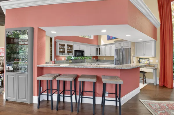 a kitchen with white cabinets a sink and appliances