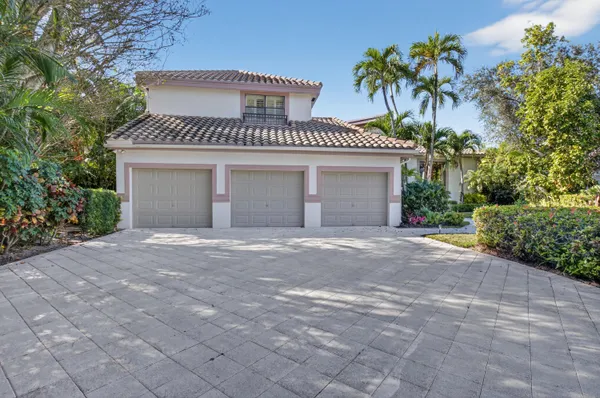 a view of a house with a yard and palm trees