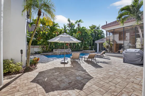 a view of a patio with a table and chairs under an umbrella