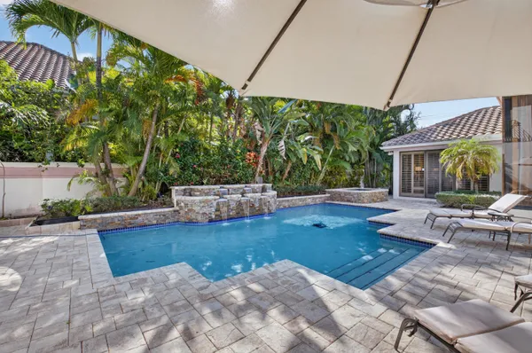a view of a patio with a table and chairs under an umbrella